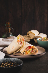 Homemade shawarma with chicken, tomato and cucumber in pita bread vertical view