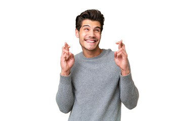 Young handsome caucasian man over isolated background with fingers crossing