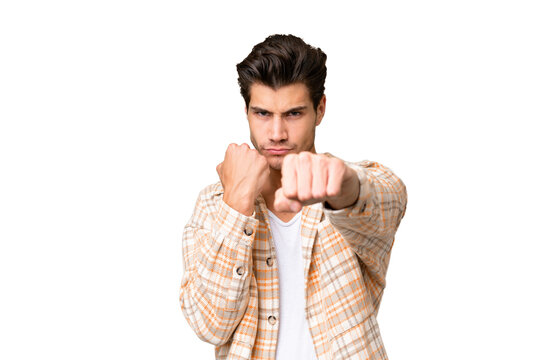 Young handsome caucasian man over isolated background with fighting gesture