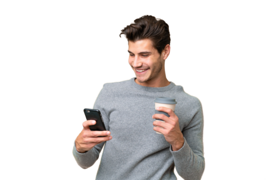 Young handsome caucasian man over isolated background holding coffee to take away and a mobile