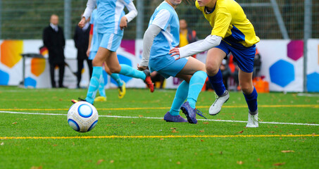 Girls football players legs struggling for the ball on the soccer field