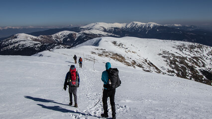 Backpackers hiking in Tatras mountains in snowy winter.