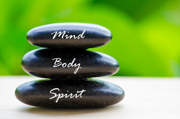 Close up of black Zen stones with Mind Body and Spirit text on the stones. Zen and peaceful concept