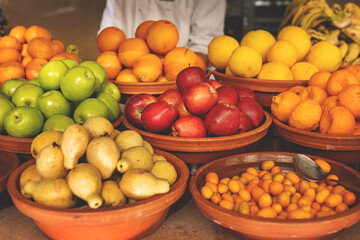 Delicious buffet table with Fresh and Vibrant fruits in Rustic Clay Bowls, featuring variety of healthy and colorful plant-based dishes for vegetarian or vegan meal in Fruit shop, market or hotel