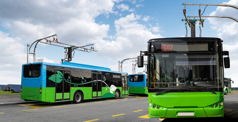 Electric buses at a stop are charged by pantograph. Solar panels in the background