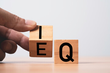 Hand flipping wooden block cube for balance between intelligence quotient (IQ) and emotional...