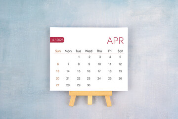 April 2025 calendar page with wooden easel.