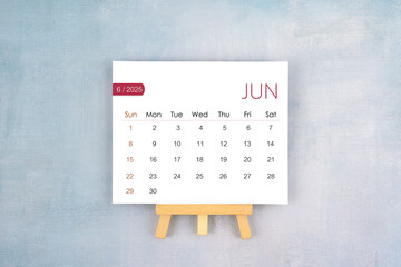 June 2025 calendar page with wooden easel.