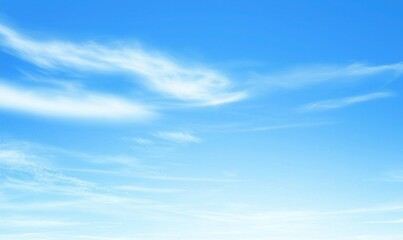 A bright, clear sky with soft white clouds drifting lightly across the vast blue expanse above the horizon