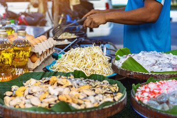 Bean sprouts in basket and chicken eggs and vegetable oil and blurred image of seafood meat food and chef cooking in foreground and background. Ingredients for Crisp fried mussel or seafood pancake.