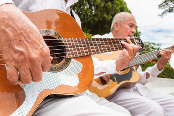 Detail of an acoustic guitar being played by a mature Colombian man in a musical duet in Yaguara, Huila, Colombia. Colombian music concept