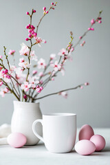 Spring still life with blank white mug mockup, easter eggs and blooming spring branches on light background