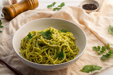 Vegetarian vegan green pasta, Spaghetti pasta with broccoli pesto sauce and vegan cheese in white plate.Healthy food.