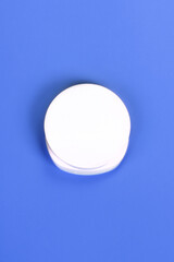 Minimalist white cosmetic jar on a vibrant blue background. Ideal for skincare, beauty, and product branding concepts.