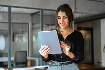Latina Hispanic young adult professional business woman looking at pc device computer screen....