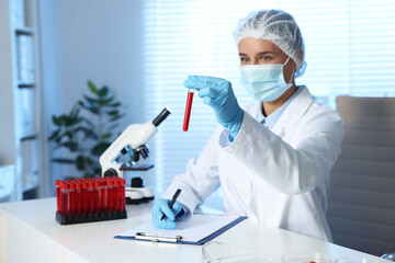 Laboratory testing. Doctor with blood sample working at table indoors