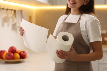Woman using paper towels in kitchen, closeup