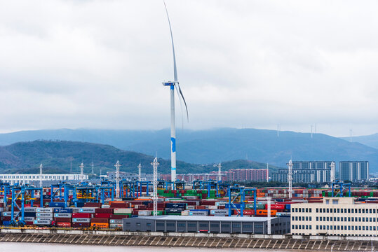 Container terminal in Ningbo Zhoushan, China. View on the port and windmill supplying a green energy. 
