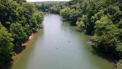 Areal view of two kayaks paddling down the Etowah River lined by trees in Northern Georgia
