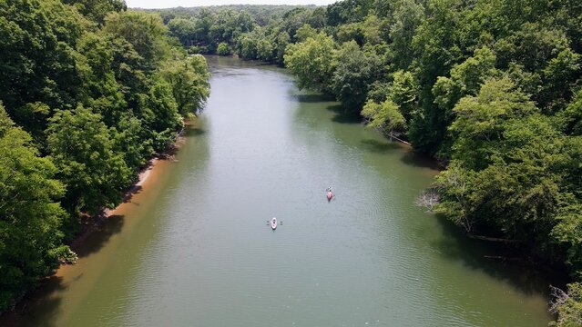 Areal view of two kayaks paddling down the Etowah River lined by trees in Northern Georgia