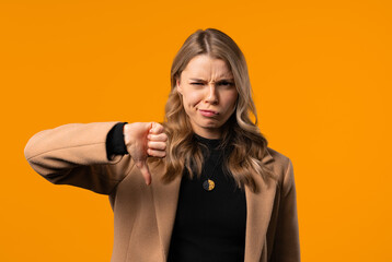 Businesswoman with sign dislike. Grimacing condemning lady showing thumbs-down