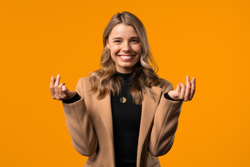 Young Businesswoman With Money Gesture On Yellow Studio Background. Smart