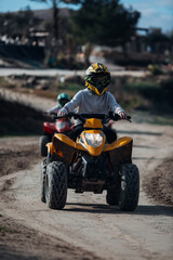 Kids riding a quad bike in the desert