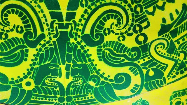 A green and yellow design with a man's face on it. The man's face is surrounded by a lot of detail