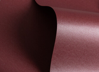 Elegant dark burgundy paper texture with a pearlescent shimmer and glossy finish. Rich and reflective designer material with a subtle glittering effect, perfect for luxury stationery, artistic.