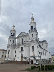 Fototapeta premium Large white church with golden domes and crosses under a bright blue sky 