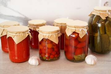 Homemade canned jar with salted tomatoes and cucumbers on table with garlic and spices on white background. Food stock. Healthy food. Harvesting.
