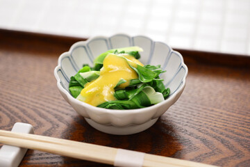 boiled young daylily leaves topped with mustard and vinegared miso. An spring appetizer of Japanese cuisine.