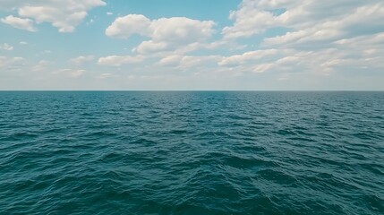 Obraz premium Ocean surface, horizon view, blue sky with clouds background, used for travel or nature themes