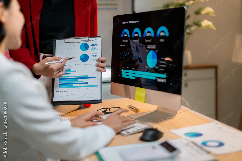 Poster businesswomen analyzing financial charts and graphs on computer and clipboard discussing company str