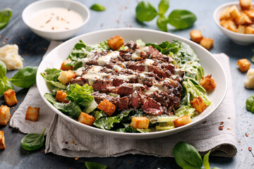 Beef steak Caesar salad with croutons, parmesan cheese and lettuce. Healthy food
