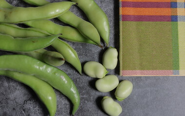habas frescas sobre mantel vainas peladas