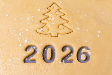 New year 2026. Cooking homemade cookies. Cutting out cookies in shape of the number 2024 and...