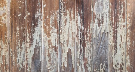The texture of old brown wood has peeling paint and scratches. The wall or fence has deteriorated over time. Texture image.