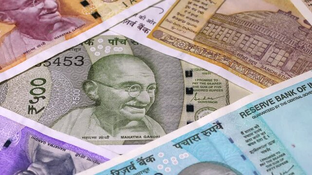 Panoramic top view of Indian banknotes (INR) of 50, 100, 200 and 500 rupees laying on the table surface. Close-up portrait of Mahatma Gandhi on the five hundred rupee note.