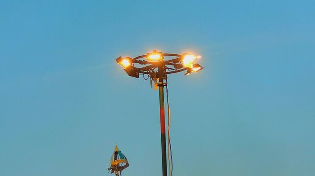 Big lights mounted on a tall pole in a stedium 