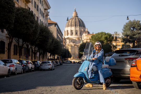 Fototapeta A stylish traveler on a scooter explores the streets of Rome with St. Peters Basilica in the background. This image captures the essence of urban adventure, freedom, and Italian lifestyle