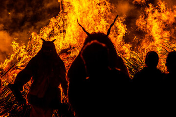 Silhouette of devil monster in front of a huge fire
