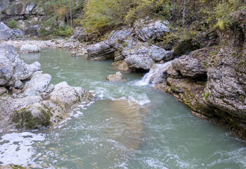 a stream of water in a stone riverbed, spewing noise and rumbling, making its way to free water