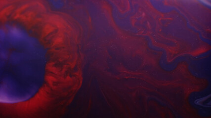 Blend splash. Fluid spill. Defocused purple red colorful paint chemical marble emulsion in water...