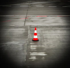 Orange traffic cone on the asphalt near the runway
