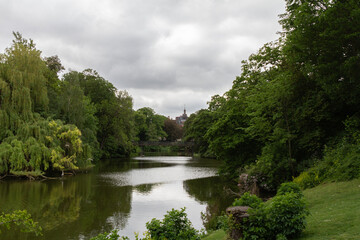 Fototapeta premium A serene view of a river running through Copenhagen, surrounded by lush green trees.
