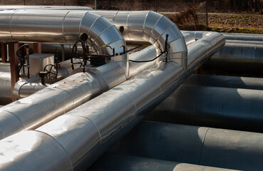 Insulated metal pipelines with valves, part of an industrial system for transferring heat, gas, or...
