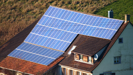Solar panels installed on a residential roof in a countryside setting during bright daylight hours