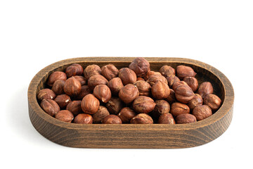 Hazelnuts in a wooden bowl isolated on white background.