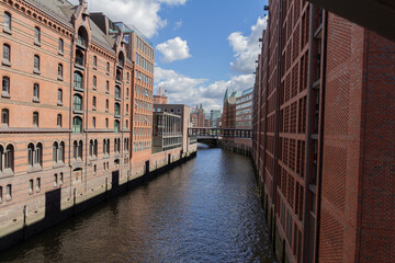 Fototapeta premium A view of the Hamburg Warehouse District (Speicherstadt), a UNESCO World Heritage site, with its red brick buildings, canals, and historic warehouses.